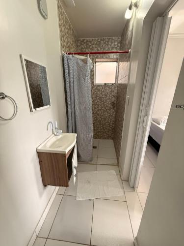 a bathroom with a sink and a shower at Pousada Hotel Canto dos Mares in Guarujá