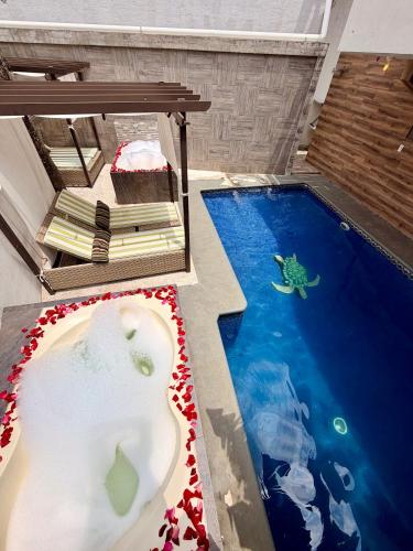 a swimming pool with a bath tub in the middle of it at Loft Lujo Estilo y Diseño, alberca con calefacción! Cuernavaca somos los únicos en ofrecerte 2 jacuzzis tipo Spa con agua caliente y sistema de hidromasaje, elegante y amplia cama de alberca, 3 Smart TV, terraza privada con asador de carbon, WiFi gratis! in Cuernavaca
