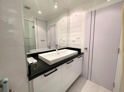 a bathroom with a sink and a mirror at Beautiful Sea View Cozy Condo in Pattaya South