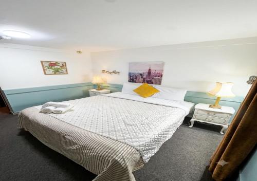 a bedroom with a large bed and two lamps at The Grand Wanganui in Whanganui