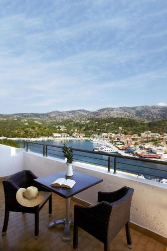a balcony with a table and chairs and a view of a harbor at Panorama Botsaris Apartments in Sivota
