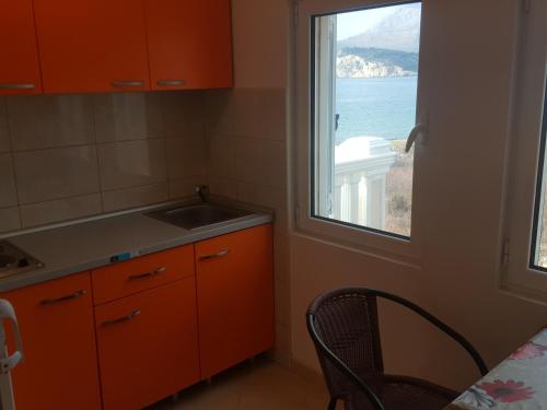 a kitchen with a window and a sink and a table at Buljarica Bay Apartments in Petrovac na Moru