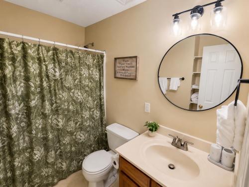 a bathroom with a sink and a toilet and a mirror at Spacious 3BR Retreat Perfect for Groups Near Downtown in Raleigh