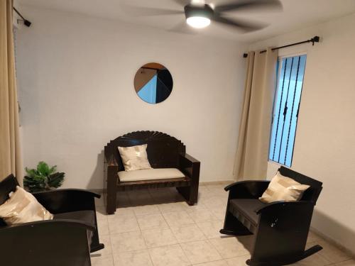 a living room with two chairs and a ceiling fan at Casa Amplia San Pedro Norte Cerca Fco Montejo in Mérida