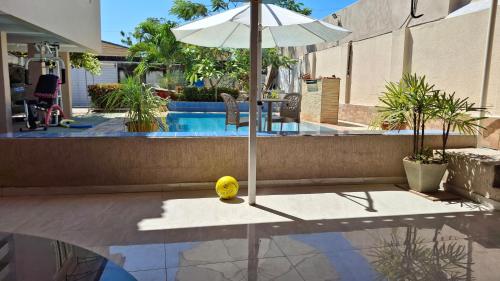 a tennis ball on a table next to a pool at Maktub Estadia e recepções in Paulista