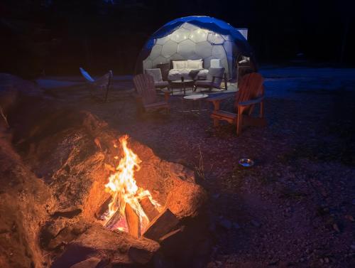 a tent with a bed and a fire in front of it at Rare Mirrored Glamping Dome in Severn