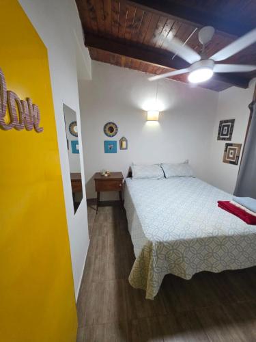 a bedroom with a bed and a yellow wall at El Refugio Misiones in Garupá