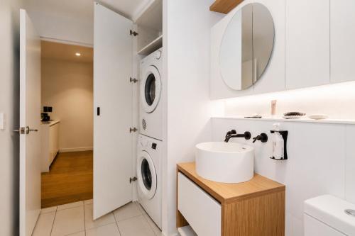 a bathroom with a sink and a washing machine at Punthill Ivanhoe in Melbourne