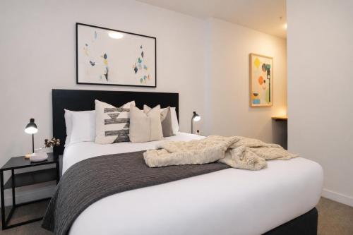 a bedroom with a large white bed in a room at Punthill Ivanhoe in Melbourne