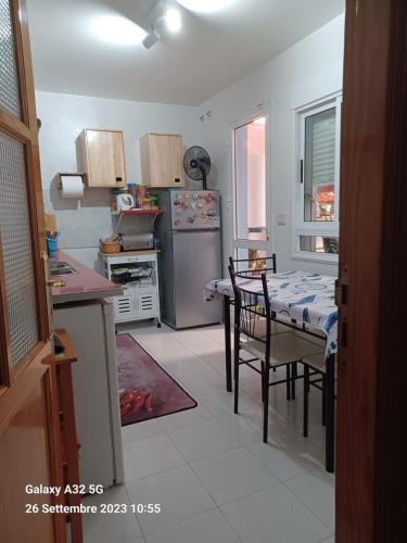 a kitchen with a table and a stainless steel refrigerator at Habitaciones Gioly in Puerto del Rosario