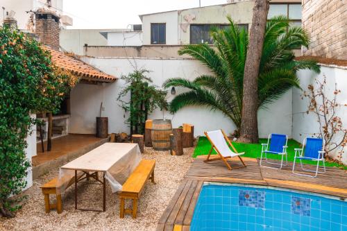 a backyard with a table and chairs and a pool at Pulkay Hostel Folk in Mendoza