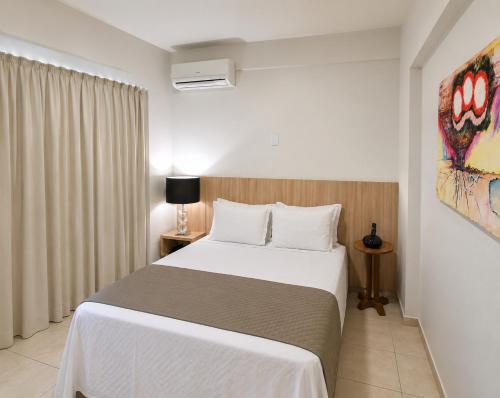 a bedroom with a large white bed in a room at Corumbá Plaza Hotel in Luziânia
