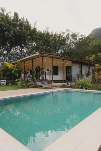 a swimming pool in front of a house at ALMAH GLAMPING in Cali