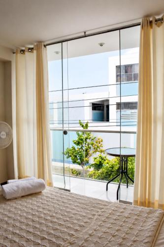 a bedroom with a bed and a large window at Hotel Inkayacu in Paracas