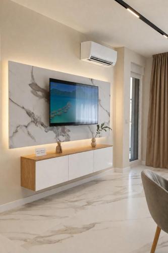 a living room with a television on a wall at Nikol River Residence in Sandanski