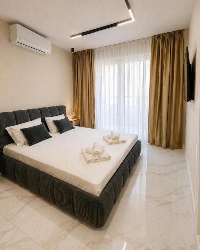 a bedroom with a large bed with two towels on it at Nikol River Residence in Sandanski