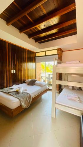 a bedroom with two beds and a balcony at Hotel Boutique El Mirador in Arboletes