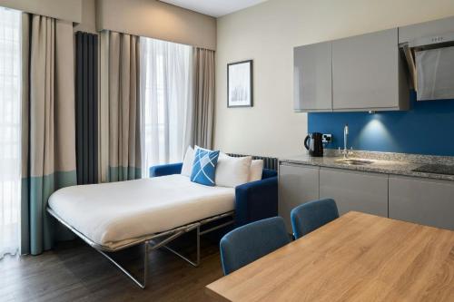 a room with a bed and a table and a kitchen at Four Points Flex by Sheraton Edinburgh in Edinburgh