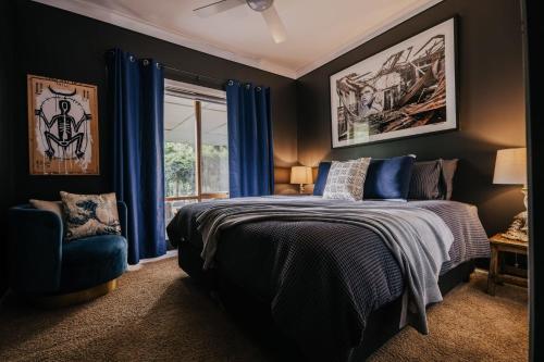 a bedroom with a bed and a window with blue curtains at Istana Lodge in Musk Vale