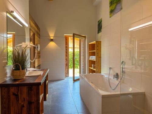 a large bathroom with a tub and a sink at Bellone 52 in Lake Pressegg
