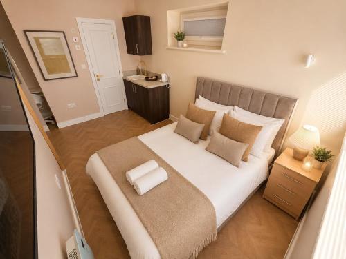 a bedroom with a large white bed with pillows at Hayes Studios near Heathrow in Northolt