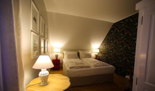 a bedroom with a bed and a lamp on a table at Alwine - Landhaus an den Spreewiesen in Rietz Neuendorf