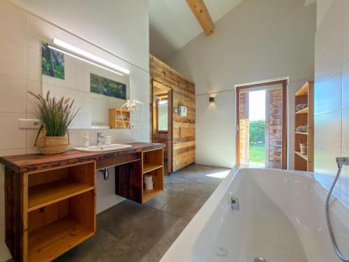 a bathroom with a large tub and a sink at Trebas 51 in Lake Pressegg