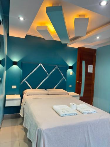 a blue bedroom with a bed with two towels on it at Inti killa in Huánuco