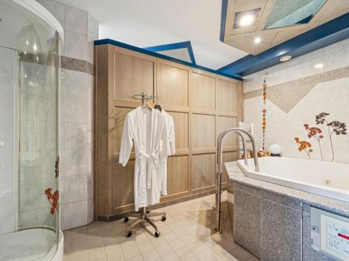 a bathroom with a tub and a robe on a rack at Traudi in Waldkirchen
