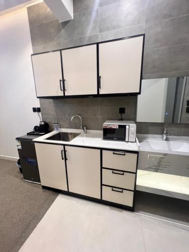a kitchen with a sink and a microwave at شقق فاخرة in Mahlal