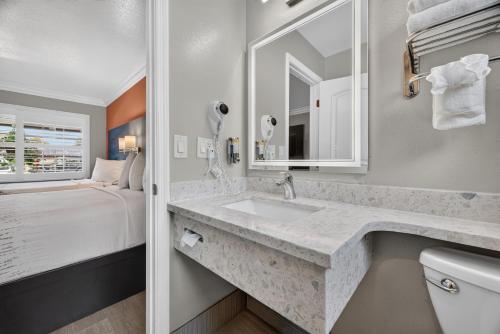 a bathroom with a sink and a bed at Padre Oaks in Monterey