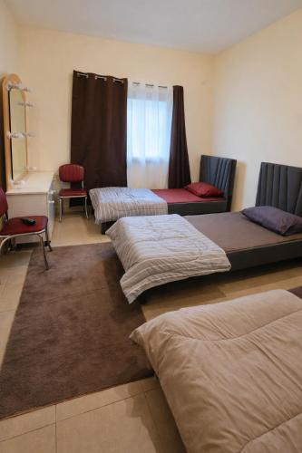 a room with three beds in a room at Iman Guest House in Al Qurayyah