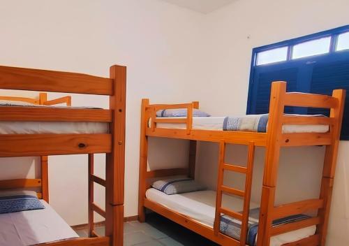 a room with three bunk beds and a window at Armorial Hostel in João Pessoa