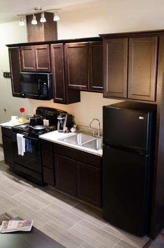 a kitchen with a black refrigerator and a sink at Inn at Moses Lake with Extended Stay in Moses Lake