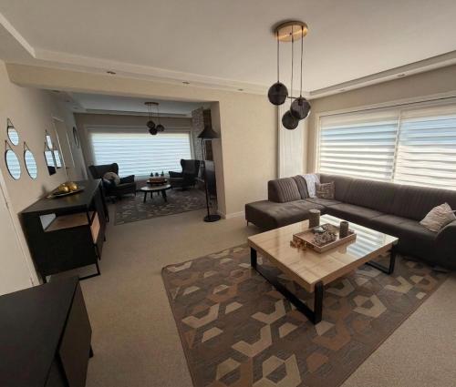 a living room with a couch and a coffee table at Negenendertigtwintig-Lommel in Lommel