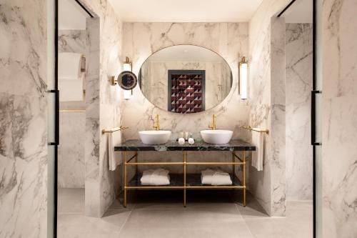 a bathroom with two sinks and a mirror at Le Meridien Visconti Rome in Rome