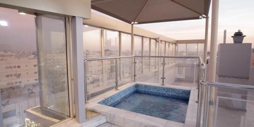 a hot tub on the balcony of a building at Areen Almatar Serviced Apartments شقق ارين المطار للشقق المخدومة in Jeddah
