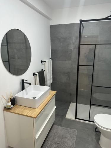a bathroom with a white sink and a mirror at Renna in Corroios