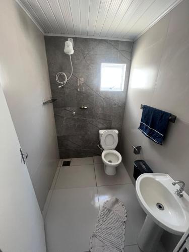 a small bathroom with a toilet and a sink at Casa proxima ABQM in Araçatuba
