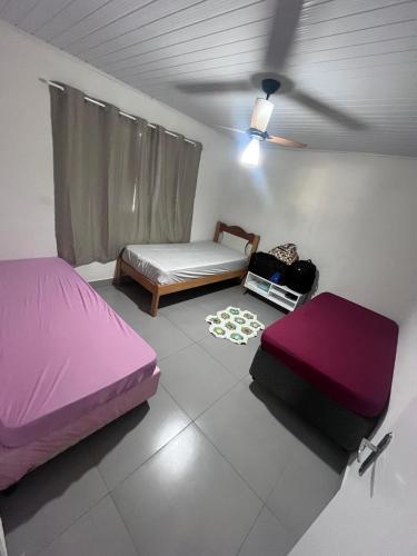 a bedroom with two beds and a ceiling fan at Casa proxima ABQM in Araçatuba