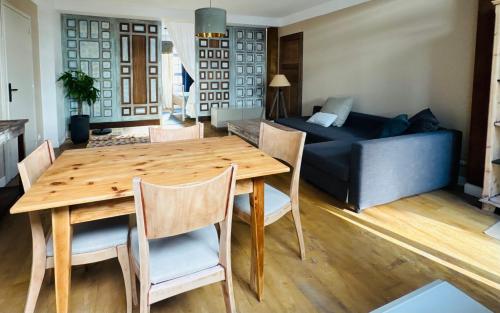 a living room with a wooden table and a couch at El cuarto AZUL in Urrugne