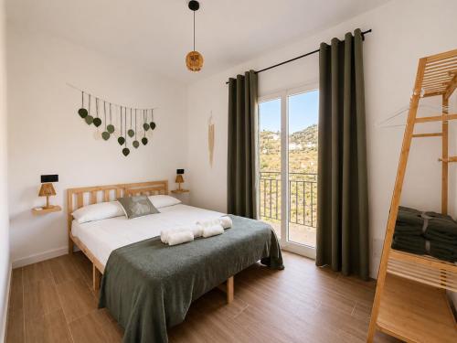 a bedroom with a bed and a ladder and a window at Apartamento Torrox Village 2 in Torrox
