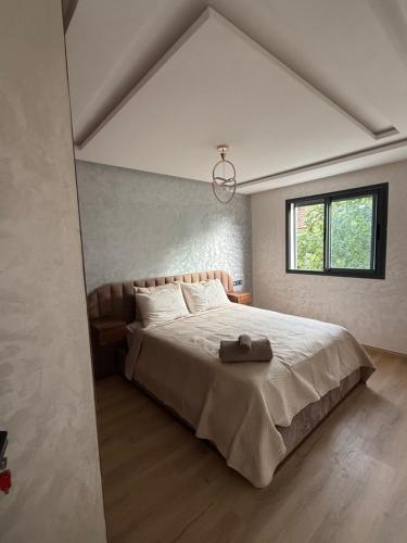 a bedroom with a large bed and a window at Appartement avec balcon vue sur forêt - centre ville in Ifrane