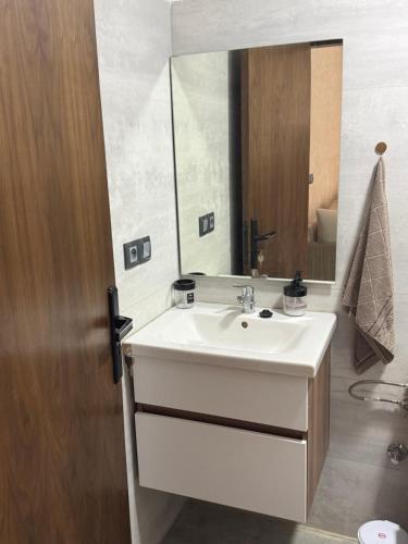 a bathroom with a white sink and a mirror at Appartement avec balcon vue sur forêt - centre ville in Ifrane