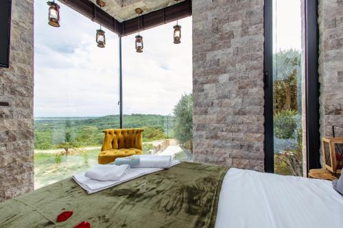 a room with a bed and a chair in front of a large window at Countryside in Ulcinj