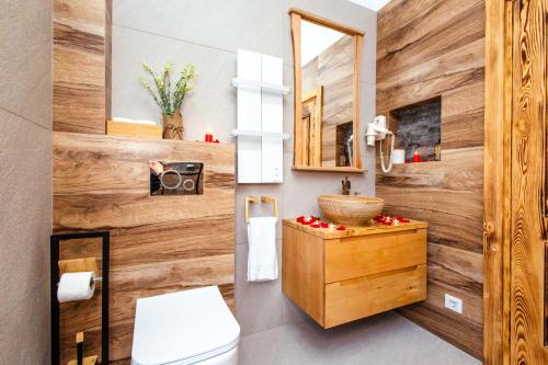 a bathroom with a wooden wall with a toilet and a sink at Countryside in Ulcinj