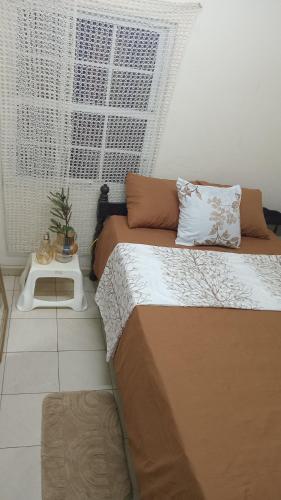 a small bedroom with two beds and a table at Tiny house in Paramaribo