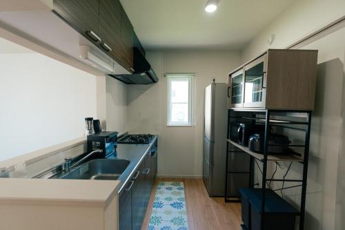 a kitchen with a sink and a refrigerator at ビアンカ Bianca A号室 in Asahikawa