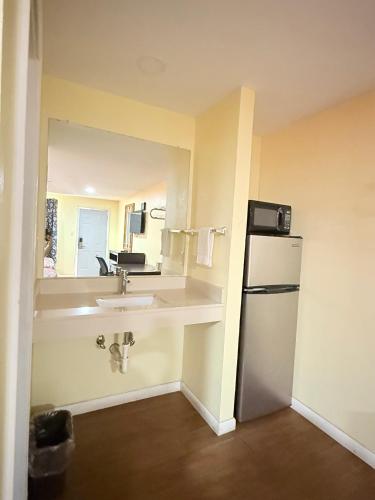 a small kitchen with a sink and a refrigerator at Budget Inn in Vidalia