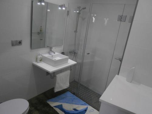 a bathroom with a sink and a shower and a toilet at Casa Das Dias in Vila Franca do Campo